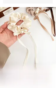 Detail of satin scrunchies with glittering rhinestones, pearls and long ribbons