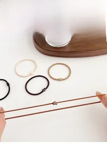 Detail view of high-elasticity hair ties with matte heart charms in coffee tones