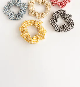 Set of five colorful plaid scrunchies with soft cotton fabric texture shown from above