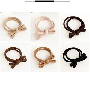 Detailed grid view of six assorted bow hair ties in neutral beige and brown tones