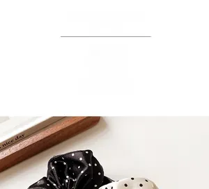Close-up of French style polka dot satin scrunchies in black and white colors