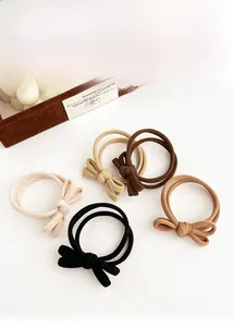 Detailed view of elastic bow hair ties in neutral beige and brown earth tones