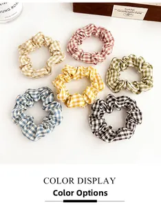 Macro detail of six checkered scrunchies set in pastel colors with soft cotton texture