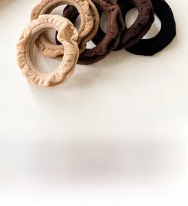 Close-up of ruffled hair scrunchies in neutral earth tones with soft ribbed fabric texture
