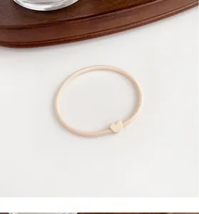 Detailed view of cream-colored heart hair tie with durable high-elasticity rubber band