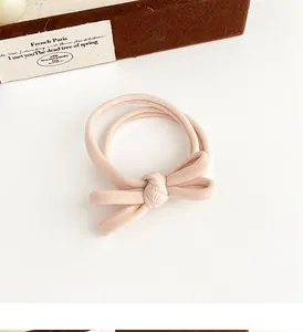 Detailed view of milk coffee bow scrunchie with soft ribbed elastic fabric texture