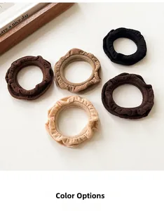 Detail of five ruffled hair scrunchies in earthy coffee tones on a white background