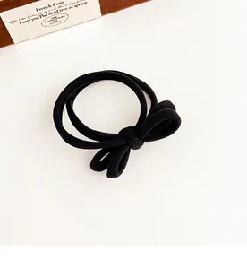Detail of black bow hair tie featuring high-elasticity ribbed knit texture and seamless design