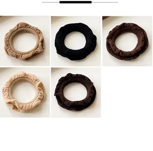 Detail of ruffle edge hair ties in five neutral earth tones with ribbed knit texture