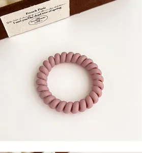 Gros plan sur l'élastique spirale rose poudré mat avec une texture douce et souple