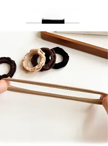 Macro detail of high-elasticity ruffled hair ties in neutral brown and beige tones