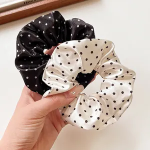 Set of two French polka dot satin scrunchies in black and beige for elegant hair styling