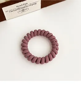 Vue détaillée d'un chouchou spirale rose foncé mat avec texture flexible en cordon de téléphone