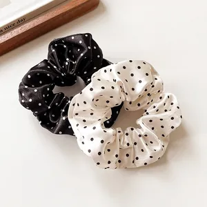 Polka dot satin scrunchies set in black and cream with a silky finish for hair styling
