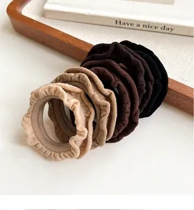 Detailed texture of pleated fabric hair scrunchies in neutral beige and coffee tones