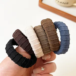 Five durable high-elasticity ribbed hair ties in earthy tones on a minimalist background