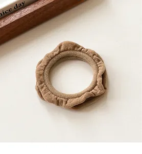 Detail of coffee ruffle scrunchie showing cotton texture and high elastic inner band