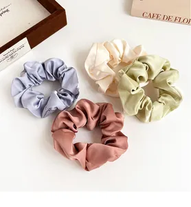 Detailansicht von 4 Satin-Haargummis in Lavendel, Beige, Grün und Braun im Set