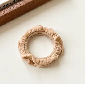 Close-up of beige ruffled hair scrunchie showing premium pleated fabric texture