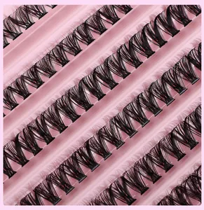 Detailed macro view of 40D black individual cluster lashes on a pink striped tray