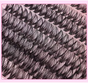 Macro di singoli ciuffi di ciglia finte in fibra nera su un delicato sfondo rosa tenue