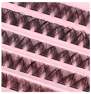 Macro shot of tiered black cluster eyelashes on a pink tray for DIY lash extension