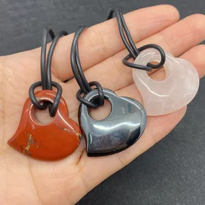 Detailweergave van hartvormige hangers van natuursteen in rood, zwart en roze met koord