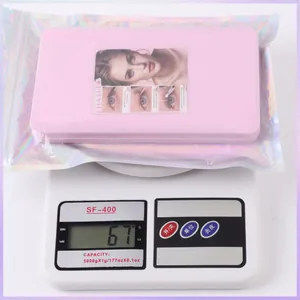 Detailed view of individual cluster lashes in pink box packaging weighed on a scale