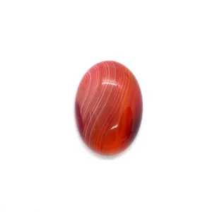 Macro view of polished oval red striped agate gemstone with natural white patterns