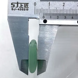 Macro shot measuring 8.8mm thickness of polished green aventurine rune stone with caliper