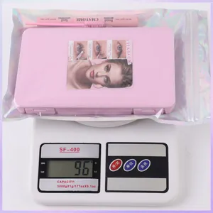 Lash extension kit with glue and tweezers in holographic bag on scale for weight detail