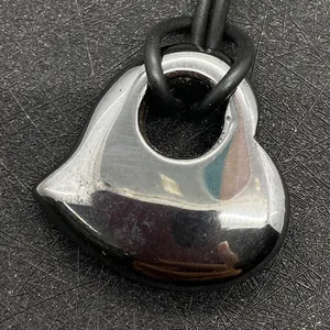 Macro-opname van hartvormige hematiet hanger met metaalglans aan een zwart koord