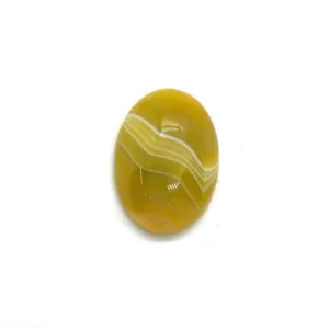 Macro detail of oval yellow striped agate cabochon with smooth polished surface