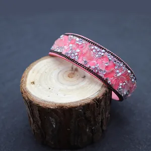 Detail of pink natural stone chips and silver rhinestones on a leather bracelet