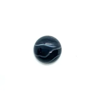Macro view of polished round black striped agate stone with white wave patterns