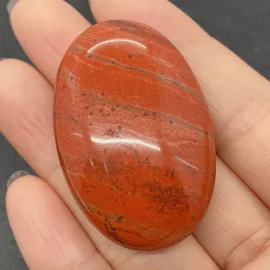 Macro detail of polished oval Red Jasper stone showing natural dark veins and patterns