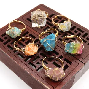 Detalle de siete anillos artesanales de cristal en bruto envueltos en estilo boho