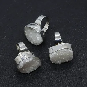 Detail of three raw white druzy crystal rings with silver-toned edge plating
