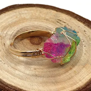 Detalle del anillo artesanal de hilo dorado con cristal de piedra natural de colores
