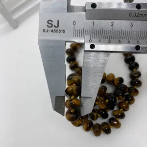 Dettaglio della misurazione di perline occhio di tigre da 8 mm con un calibro digitale