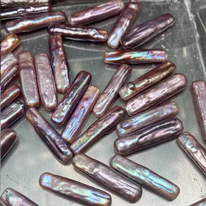 Makroaufnahme langer Barockperlen mit lila Metallglanz und Regenbogen-Irisieren