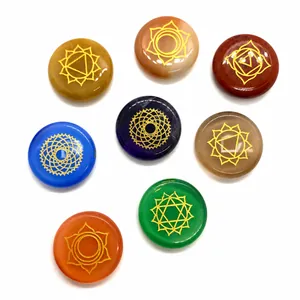 Detailed macro view of 8 polished chakra stones with engraved golden spiritual symbols