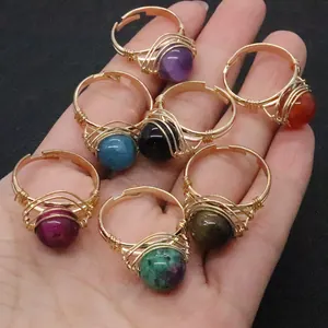 Macro shot of handmade wire-wrapped rings featuring natural gemstone round beads