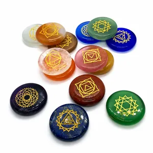 Close-up of polished natural chakra stones with engraved golden spiritual symbols