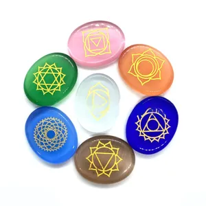 Detailed view of seven chakra stones with gold engraved symbols on polished oval crystals