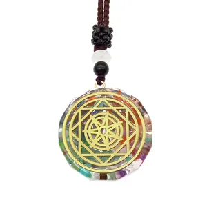 Gros plan du pendentif Orgone avec pierres naturelles colorées et totem géométrique doré