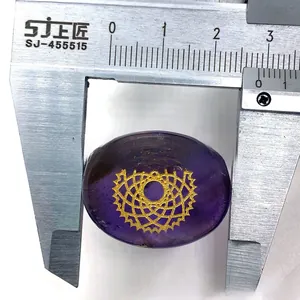 Measuring the width of an oval purple chakra stone with a metal caliper for accuracy