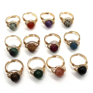 Set of 12 handmade wire-wrapped gold rings featuring round natural stone beads in various colors