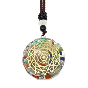Détail d'un pendentif en cristal coloré avec motif chakra et cordon tressé