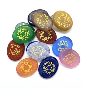 Close-up of colorful chakra energy stones with golden engraved spiritual symbols